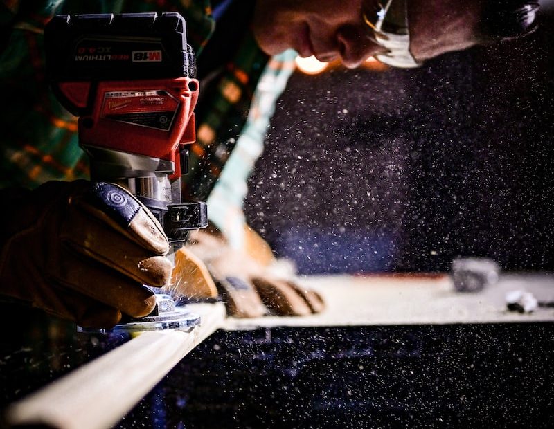 person holding orange and black power tool